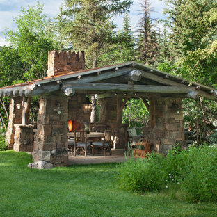 Esempio di un patio o portico rustico di medie dimensioni e dietro casa con un focolare, pavimentazioni in pietra naturale e un gazebo o capanno