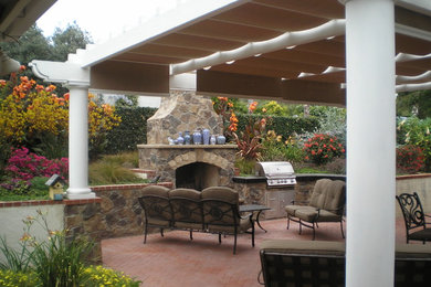 Patio - large mediterranean backyard brick patio idea in San Diego with a fire pit and a pergola