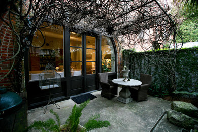 На фото: двор среднего размера на заднем дворе в средиземноморском стиле с летней кухней и мощением тротуарной плиткой с