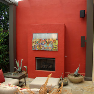 Ispirazione per un grande patio o portico minimal dietro casa con un caminetto e una pergola