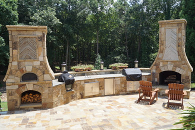 Huge mountain style backyard stone patio kitchen photo in Atlanta with no cover