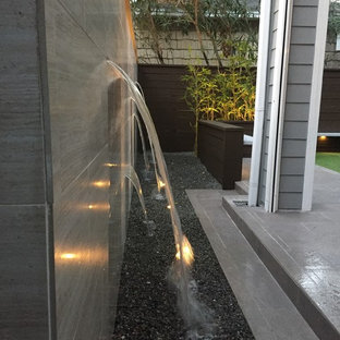Immagine di un piccolo patio o portico design dietro casa con fontane, graniglia di granito e nessuna copertura