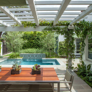 Ejemplo de patio mediterráneo, de tamaño medio, en patio trasero, con fuente, adoquines de hormigón y pérgola