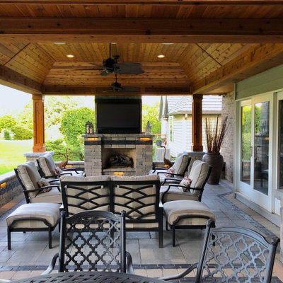 Inspiration for a mid-sized rustic backyard patio remodel in Chicago with a fireplace and a roof extension