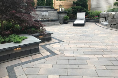 Large minimalist backyard concrete paver patio photo in Other