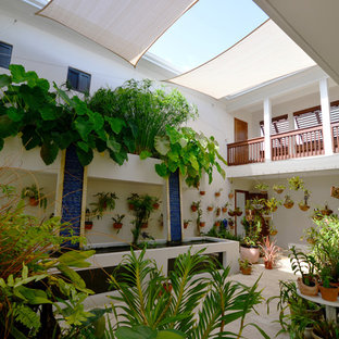 Immagine di un patio o portico tropicale di medie dimensioni con un parasole