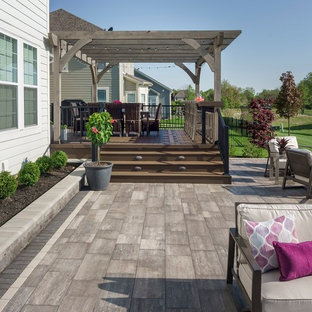 Esempio di un ampio patio o portico eclettico dietro casa con un focolare, pavimentazioni in mattoni e una pergola