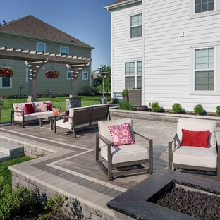 Immagine di un ampio patio o portico boho chic dietro casa con un focolare, pavimentazioni in mattoni e una pergola