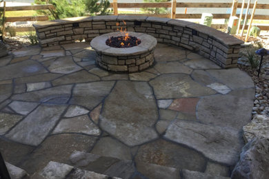 Inspiration for a mid-sized rustic backyard stone patio remodel in Denver with a fire pit and no cover