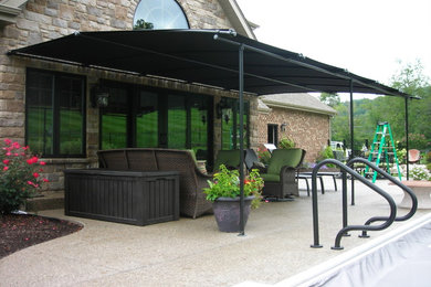 Foto di un patio o portico minimalista dietro casa con un parasole