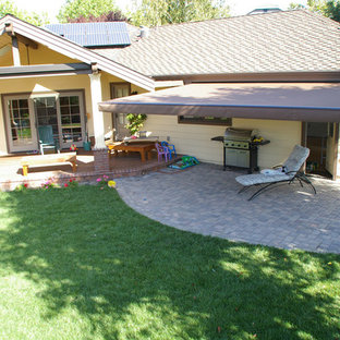 Foto di un patio o portico american style di medie dimensioni e dietro casa con un parasole e pavimentazioni in mattoni