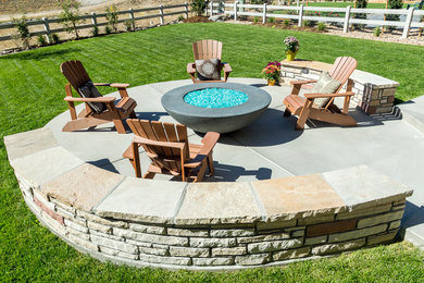 Example of a large classic backyard concrete patio design in Denver with a fire pit and no cover