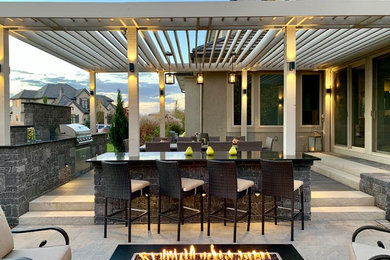 Patio - modern backyard concrete paver patio idea in Kansas City with a fire pit and a pergola