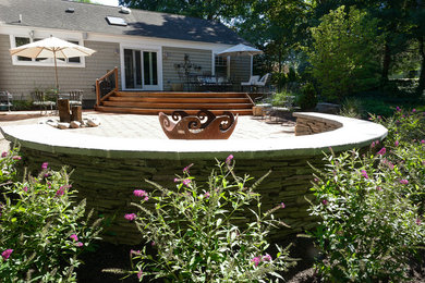 Mid-sized mountain style backyard brick patio photo in New York with a fire pit