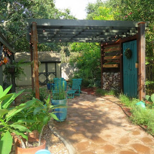Idee per un patio o portico boho chic di medie dimensioni e dietro casa con un giardino in vaso, pavimentazioni in cemento e una pergola