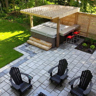 Foto di un patio o portico minimalista di medie dimensioni e dietro casa con piastrelle e una pergola