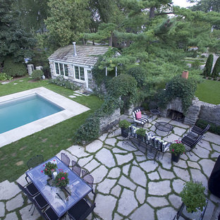 Foto di un grande patio o portico bohémian dietro casa con un focolare, pavimentazioni in pietra naturale e nessuna copertura