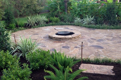 Inspiration for a large timeless backyard stone patio remodel in New Orleans with a fire pit and no cover