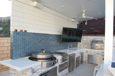 Ejemplo de patio contemporáneo de tamaño medio en patio trasero y anexo de casas con cocina exterior y suelo de baldosas