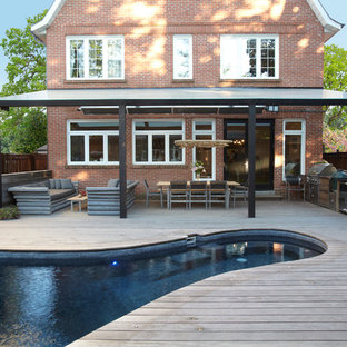 Esempio di un grande patio o portico scandinavo dietro casa con pedane e un tetto a sbalzo
