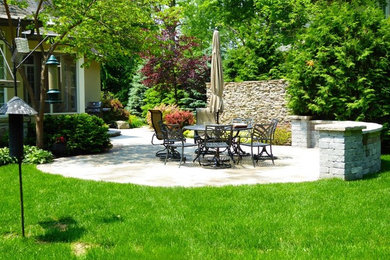 Imagen de patio clásico de tamaño medio en patio trasero con brasero, adoquines de piedra natural y pérgola