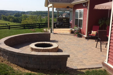 Example of a mid-sized farmhouse backyard concrete paver patio design in Other with a fire pit
