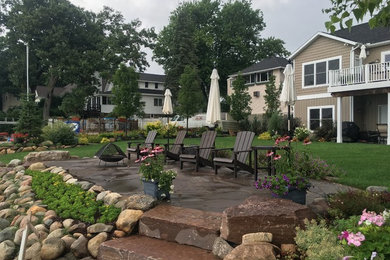 Patio - mid-sized coastal backyard brick patio idea in Grand Rapids with no cover