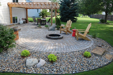 Inspiration for a timeless backyard brick patio remodel in Other with a fire pit and a pergola