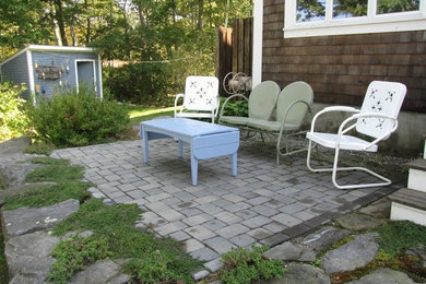 Example of a backyard brick patio design in Portland Maine with no cover