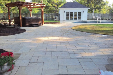 Example of a classic backyard stone patio design in Little Rock with no cover