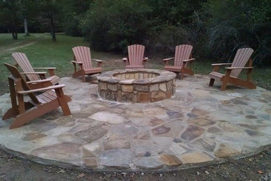 Example of a mid-sized mountain style backyard stone patio design in Houston with a fire pit and no cover