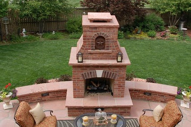 Example of a large classic backyard stone patio design in Denver with a fire pit and no cover