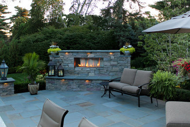 Large elegant backyard stone patio photo in Detroit with a fire pit and no cover