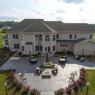 Example of a huge transitional backyard stamped concrete patio kitchen design in DC Metro with a pergola