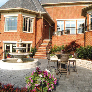Esempio di un patio o portico classico di medie dimensioni e dietro casa con fontane, cemento stampato e nessuna copertura