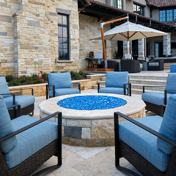 Backyard Stone Fire Pit With Woven, Upholstered  Arm Chairs