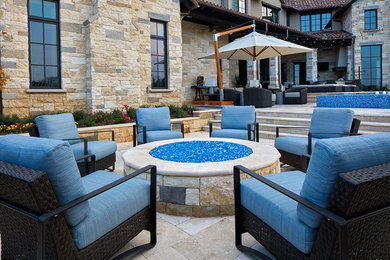 Huge transitional backyard stone patio photo in Dallas with a fire pit and no cover