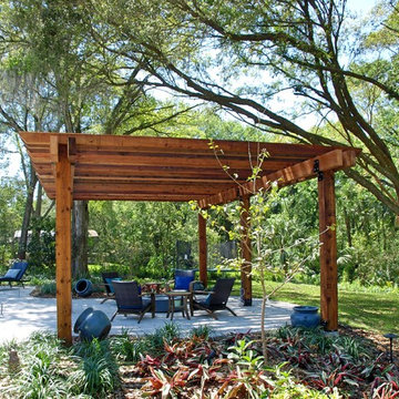 Backyard Tudor revival landscape along a natural area with a stream