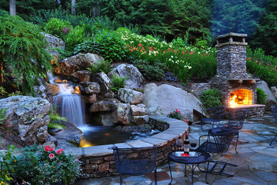 Patio fountain - large contemporary backyard stone patio fountain idea in Other with no cover