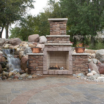 Backyard waterfalls and fireplace comforting a patio