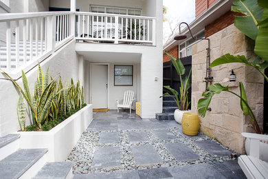 Imagen de patio marinero de tamaño medio sin cubierta en patio con ducha exterior y adoquines de piedra natural