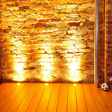Bamboo decking with galvanised down pipe & in-deck lights on brick feature wall