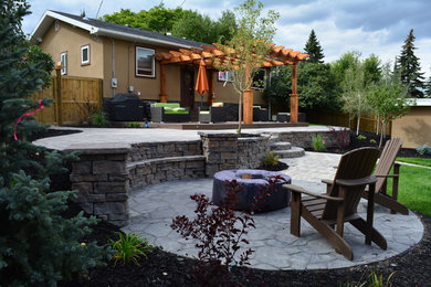 Mountain style backyard brick patio photo in Calgary with a gazebo