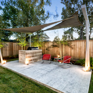 Foto di un patio o portico minimal dietro casa con pedane e un parasole