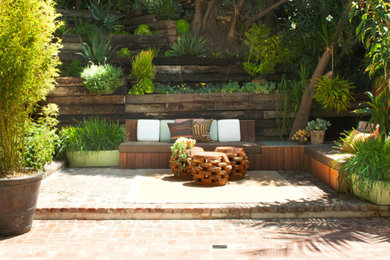 Modelo de patio exótico de tamaño medio sin cubierta en patio trasero con jardín de macetas y adoquines de ladrillo