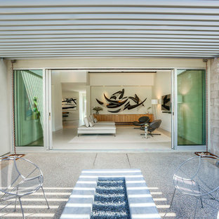 Esempio di un patio o portico moderno di medie dimensioni e dietro casa con una pergola, un focolare e graniglia di granito