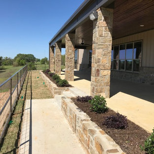 Idee per un grande patio o portico country dietro casa con lastre di cemento e un tetto a sbalzo