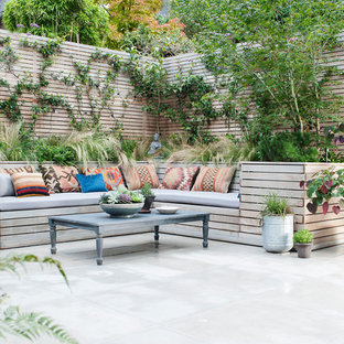 Foto di un piccolo patio o portico eclettico con un giardino in vaso e pavimentazioni in pietra naturale