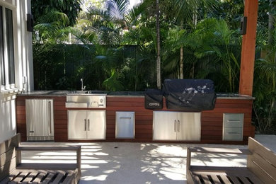 This is an example of a contemporary patio in Miami with an outdoor kitchen.