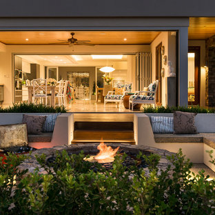 Esempio di un grande patio o portico country davanti casa con un focolare, nessuna copertura e graniglia di granito